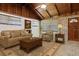 Cozy living room with wooden walls, vaulted ceiling, and comfortable seating area at 6731 Lake Griffin Rd, Lady Lake, FL 32159