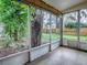 This screened-in patio offers a view of the tree-filled backyard, providing a serene retreat at 6731 Lake Griffin Rd, Lady Lake, FL 32159