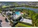 Aerial view of neighborhood clubhouse, pool, and recreational amenities near a pond at 709 Longboat Dr, Davenport, FL 33896