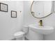 Stylish powder room with sleek fixtures and a unique round mirror, complemented by modern wall art at 709 Longboat Dr, Davenport, FL 33896
