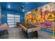 Finished garage with blue trim, painted floors, and colorful wall art for a modern entertaining space at 709 Longboat Dr, Davenport, FL 33896