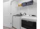 Convenient laundry room with modern washer and dryer units, plus storage shelving for supplies at 709 Longboat Dr, Davenport, FL 33896