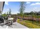 Relaxing outdoor patio area with a wrought-iron fence and a table seating four people, perfect for entertaining at 709 Longboat Dr, Davenport, FL 33896