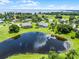 Expansive view of an estate and reflecting pond, revealing its prime placement within the neighborhood landscape at 7303 Spring Mountain Ln, Yalaha, FL 34797