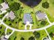 Stunning aerial view of estate home with pool, bordered in red, lush landscaping, and adjacent to pond at 7303 Spring Mountain Ln, Yalaha, FL 34797