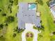 Overhead view of the home featuring a private pool, circular driveway, lush landscaping, and a sprawling roofline at 7303 Spring Mountain Ln, Yalaha, FL 34797