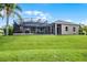 Spacious backyard featuring a screened pool area and expansive lawn, ideal for outdoor activities and relaxation at 7303 Spring Mountain Ln, Yalaha, FL 34797