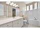 Bright bathroom featuring a vanity, toilet, tub, and glass block window for natural light at 7303 Spring Mountain Ln, Yalaha, FL 34797