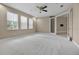 Bright bedroom featuring neutral walls, carpet flooring, multiple windows and ceiling fan at 7303 Spring Mountain Ln, Yalaha, FL 34797