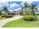 Front exterior of the home boasting a circular driveway, well-kept landscaping, and architectural charm at 7303 Spring Mountain Ln, Yalaha, FL 34797