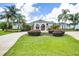 Stunning home exterior features lush landscaping, a circular driveway, and a grand entrance with arched windows at 7303 Spring Mountain Ln, Yalaha, FL 34797