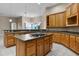 Open kitchen with a large island, wooden cabinets, and stainless steel appliances at 7303 Spring Mountain Ln, Yalaha, FL 34797