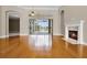 Bright living room with fireplace, hardwood floors, and sliding glass doors overlooking the pool and patio at 7303 Spring Mountain Ln, Yalaha, FL 34797