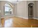Living room with wood floors, chandelier, arched doorway, and large window at 7303 Spring Mountain Ln, Yalaha, FL 34797