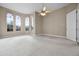 Bright main bedroom with neutral carpet, lighted ceiling fan, and bay windows at 7303 Spring Mountain Ln, Yalaha, FL 34797