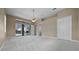 Spacious carpeted main bedroom with a ceiling fan, and access to the lanai and ensuite at 7303 Spring Mountain Ln, Yalaha, FL 34797