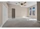 Spacious main bedroom features neutral carpet, a ceiling fan, arched windows, and closet at 7303 Spring Mountain Ln, Yalaha, FL 34797