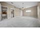 Large main bedroom featuring neutral carpet, ceiling fan, and doorways to bathroom and walk-in closet at 7303 Spring Mountain Ln, Yalaha, FL 34797
