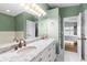 Bathroom featuring marble top double vanity, tile floor and a view into the main bedroom at 81 N Carol Ave, Mascotte, FL 34753