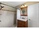 Bathroom features a standing shower, dark hardware and light tile, plus a wooden vanity at 81 N Carol Ave, Mascotte, FL 34753
