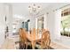 Bright dining room showcasing a large wooden table set, elegant lighting, and access to other rooms at 81 N Carol Ave, Mascotte, FL 34753