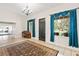 Grand entry boasts bright windows with blue curtains, a dark front door, tile floors and open access to other rooms at 81 N Carol Ave, Mascotte, FL 34753