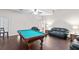 Large game room with hardwood floors, pool table, and comfortable leather seating at 81 N Carol Ave, Mascotte, FL 34753