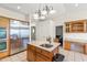 Stylish kitchen featuring stainless appliances, a granite island with sink, and ample counter space with wood cabinetry at 81 N Carol Ave, Mascotte, FL 34753