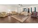 Comfortable living room with hardwood floors, multiple sofas, and a decorative area rug at 81 N Carol Ave, Mascotte, FL 34753
