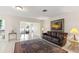 Cozy living room with dark brown leather sofa, tile flooring, and sunset artwork at 81 N Carol Ave, Mascotte, FL 34753