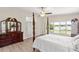 Bright main bedroom featuring lake views, a wooden four poster bed, and hardwood floors at 81 N Carol Ave, Mascotte, FL 34753