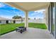 Covered back porch with an outdoor firepit, and a view of the green backyard at 853 Blue Creek Dr, Haines City, FL 33844