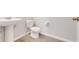 A half bathroom features a pedestal sink and wood look tile flooring at 853 Blue Creek Dr, Haines City, FL 33844