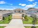 Two story home with a two car garage, green lawn, and manicured landscaping at 853 Blue Creek Dr, Haines City, FL 33844