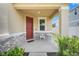 Welcoming front porch with a red door, decorative stone accents, and outdoor seating at 853 Blue Creek Dr, Haines City, FL 33844