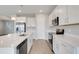Bright kitchen boasts white cabinets, stainless appliances, and a quartz countertop island at 853 Blue Creek Dr, Haines City, FL 33844