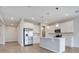 Modern kitchen with stainless steel refrigerator, white cabinets, and pendant lights over the island at 853 Blue Creek Dr, Haines City, FL 33844
