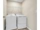 A white washer and dryer set sits in a well lit laundry room at 853 Blue Creek Dr, Haines City, FL 33844