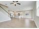 Spacious living room with modern ceiling fan flows into the bright kitchen with white cabinets at 853 Blue Creek Dr, Haines City, FL 33844