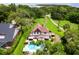 Aerial view of Tudor home featuring a pool, landscaping, and a long private driveway at 9233 Silver Lake Dr, Leesburg, FL 34788