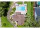 An aerial view features this home with its spacious yard, lush landscaping, and luxurious pool at 9233 Silver Lake Dr, Leesburg, FL 34788