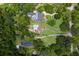 Expansive aerial view of an estate showcasing the main house, guest house, pools, lush landscaping, and surrounding greenery at 9233 Silver Lake Dr, Leesburg, FL 34788