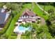 Aerial view of Tudor home featuring a swimming pool and manicured landscaping at 9233 Silver Lake Dr, Leesburg, FL 34788
