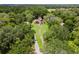 Aerial view of a Tudor style home with a long driveway surrounded by lush, mature trees at 9233 Silver Lake Dr, Leesburg, FL 34788