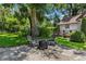 Relaxing backyard patio featuring a fire pit, chairs, and lush greenery for outdoor enjoyment at 9233 Silver Lake Dr, Leesburg, FL 34788