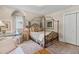 Charming bedroom featuring a four-poster bed, hardwood floors, and a bright window view at 9233 Silver Lake Dr, Leesburg, FL 34788