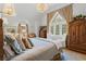 Bedroom featuring natural light from large window, with vaulted ceilings, and elegant furniture at 9233 Silver Lake Dr, Leesburg, FL 34788