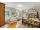 Bedroom with a decorative canopy bed, seating area, hardwood floors, and many windows with views at 9233 Silver Lake Dr, Leesburg, FL 34788