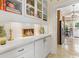 Butler's pantry featuring built-in cabinetry, display shelves, and an open pass-through to the kitchen at 9233 Silver Lake Dr, Leesburg, FL 34788