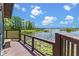 Picturesque lakeside deck featuring wooden railing, comfortable seating, and serene views of lily pads and the water at 9233 Silver Lake Dr, Leesburg, FL 34788